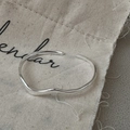 Brazalete ondulado de plata S925 minimalista sobre un fondo de bolsa de lino rústico - Estilo de Línea de Ola (SZP044) / Plata 925