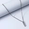 Macro shot of minimalist gunmetal rectangle bar pendant with smooth mirror finish texture - Black