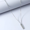 Minimalist silver stainless steel rectangle bar pendant necklace on a blue display stand - Silver