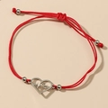 Close-up of red woven bracelet with silver hollow heart heartbeat charm and beads - Red