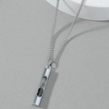 Minimalist silver hourglass pendant necklace with black sand on a grey background - Steel