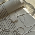 Collar de plata de ley S925 con colgante tejido cuadrado sobre un libro abierto al sol - Estilo de Textura Tejida Cuadrada (XL066) / Plata 925