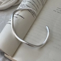 Minimalistische S925 zilveren manchetarmband met golftextuur op een open boek - Golftextuur Geborstelde Armring (SZ006)