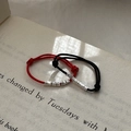 Minimalist red and black woven cord rings with adjustable silver bead design on a book - Adjustable Open / Red