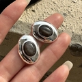 S925 sterling silver oval stud earrings with dark natural stone held in hand - Oval Black Gemstone Style (EHL068)