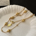 Elegante goldene S925 Silberperlenkette auf weißer Muschelschale mit Vintage-Buch präsentiert - 925er Silber / Gold (XL229)