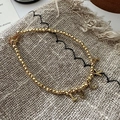 Goldenes Perlenarmband mit LUCK-Buchstabenanhängern auf beigem Hintergrund - 925er Silber / Gold (22SL35)