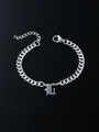 Detailed shot of silver gothic letter L pendant on a Cuban link chain bracelet - Letter L