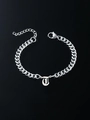 Silver Cuban link bracelet featuring a gothic letter J pendant on reflective black surface - Letter T