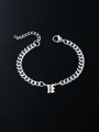 Macro detail of silver stainless steel Cuban link bracelet with Gothic letter H pendant - Letter U