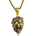 Detalle macro del colgante de cabeza de león dorado con ojos de piedras rojas y cadena - Oro champán