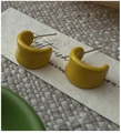 Close-up of yellow C-shaped earrings with visible S925 hallmark on silver needles - 925 Silver / Yellow