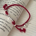 Bracelet en corde rouge et serrure en argent S925 sur fond de livre vintage - Argent 925 / Rouge