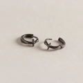 Vue macro de la boucle d'oreille croix noire avec finition polie et fermoir charnière - Argent 925 / Noir & Or