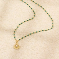 Collana a conchiglia dorata con perle verdi e ciondolo di perla su fondo morbido - Argento 925 / Oro