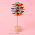 Lecca-lecca rotante Fibonacci in legno con foglie color arcobaleno su base rosa - Design a Foglia