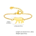 Dettaglio del bracciale con ciondolo a orso dorato, chiusura a moschettone e catenina - Oro