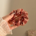 Hand met een rood-wit geblokte stoffen scrunchie met klassiek ruitjespatroon - #2 Pompoen Oranje Geruit