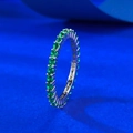 Macro di anello eternity in argento S925 con pietre verdi su sfondo blu testurizzato - US 5 / Zirconia Verde