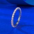 Dettaglio anello eternity in argento con cristalli rosa incastonati su sfondo blu opaco - US 5 / Rosa Strass