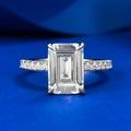 Emerald-cut sparkling stone ring with pavé side stones on elegant blue velvet background - US 5 / Platinum