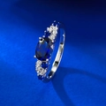 Macro-opname van S925 zilveren ring met ovale blauwe edelsteen en zijstenen - US 7 / Koningsblauw