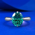 Oval cut emerald silver ring with pear shaped accents on a royal blue background - US 5 / Emerald