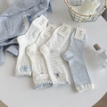Detail of four light blue and white cotton socks with cute bear embroidery and mesh texture - Mixed Colors