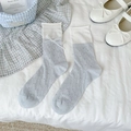 Light blue crew socks with lace bow and heart-shaped hollow knit pattern on white linen - Blue Heart