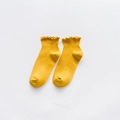 Ginger yellow cotton socks with ruffled cuffs shown in a minimalist flat lay arrangement - One Size / Yellow