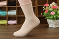 Women's 200-needle combed cotton beige loose roll-top socks shown on a foot model - One Size / Nude