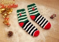 Detail of soft coral fleece Christmas socks with festive embroidery on snowy wood background - Size 37-42 / Black Green Striped Lantern