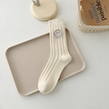 Cremeweiße Socken mit lila Smiley-Stickerei in einer gemütlichen Lifestyle-Umgebung - Einheitsgröße / Beige Lila