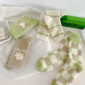 Close-up of fluffy winter socks with green patterns and soft mink velvet texture - One Size / Random Colors
