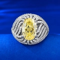 Gelber Diamantring in Eiform mit Wellen-Halo und Mikro-Pavé auf blauem Hintergrund - US 5 / Gelb