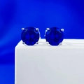Macro shot of 925 silver stud earrings with deep blue round brilliant cut gemstones - 925 Silver / Blue Rhinestone