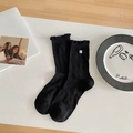 Chaussettes mi-mollet noires pour femmes avec bord à volants et écusson blanc chic - Noir Matelassé