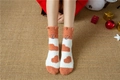 Detail of plush coral fleece Christmas socks featuring cartoon bear ears and holiday decor - White Orange Patch Paw Print (No. 6)