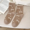Thick coffee-colored bow socks with white polka dots and fleece cuffs on beige fabric - Brown