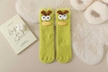 Nahaufnahme flauschiger grüner Thermosocken mit 3D-Augen und Entenschnabel für den Winter - Grüner Big-Eye-Stil / Hellgrün