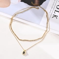 Detail of layered gold stainless steel necklace with square black pendant on a lifestyle background - Black