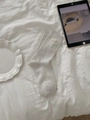 Close-up of light grey ribbed cotton socks featuring a white brand label on white bedding - One Size / Oatmeal Fabric Label Style