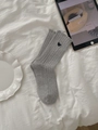 Detail view of grey ribbed knit socks featuring a small dark blue embroidered heart - One Size / Grey Heart Style