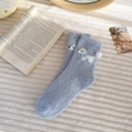 Close-up of thick light blue coral fleece winter socks with cute cartoon animal patterns - Blue