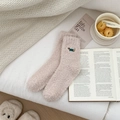 Close-up of pink coral fleece socks featuring embroidered dachshund on cozy fabric - Beige