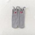 Detalle de calcetines grises de forro polar coral con orejas de conejo 3D y pompón rosa - Talla única / Gris claro