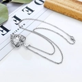 Detailopname van zilveren hartvormige medaillon ketting met levensboom op bladeren - Zilveren Hartvormige Holle Stijl (C#)