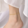 Detailaufnahme einer minimalistischen goldenen Edelstahl-Fußkette mit rechteckigen Anhängern - Streichholz Paddel Stil