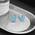 Detalle de pendientes de corazón en plata S925 con esmalte azul y textura de arena fina - Azul