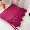 Sciarpa spessa rosa fucsia effetto cashmere con lunghe frange su un tavolo bianco - Rosa Rossa